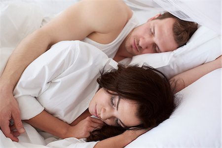 sleepy woman - Young couple asleep in bed Stock Photo - Premium Royalty-Free, Code: 649-08577805