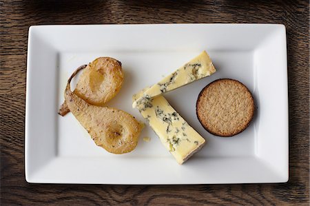 fromage bleu - Overhead view of stilton, poached pears and crackers on cheese board Photographie de stock - Premium Libres de Droits, Code: 649-08577835