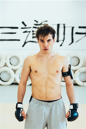 simsearch:614-07194427,k - Man in gym wearing kickboxing gloves and heart rate monitor looking at camera Stock Photo - Premium Royalty-Free, Code: 649-08577874