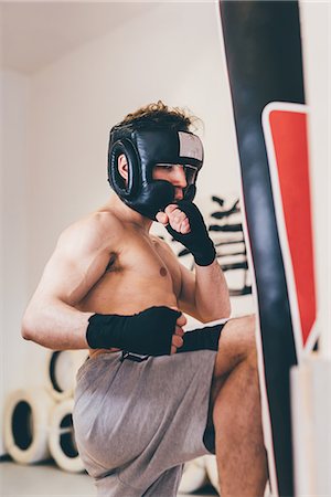 simsearch:614-07194427,k - Man wearing head protector sparring with punchbag Stock Photo - Premium Royalty-Free, Code: 649-08577882