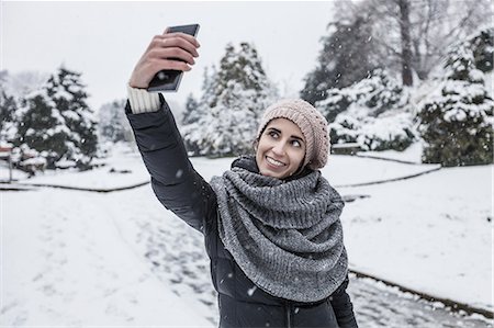 Woman on snow covered landscape using smartphone to take selfie Foto de stock - Royalty Free Premium, Número: 649-08577907