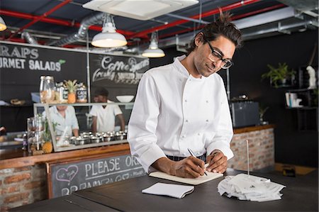 stylo plume - Chef in restaurant writing in notepad Photographie de stock - Premium Libres de Droits, Code: 649-08578053