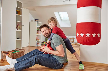 Boy wearing boxing gloves hugging father Stock Photo - Premium Royalty-Free, Code: 649-08578060