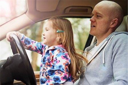 dad kid drive car - Daughter sitting on father lap driving car Stock Photo - Premium Royalty-Free, Code: 649-08578154