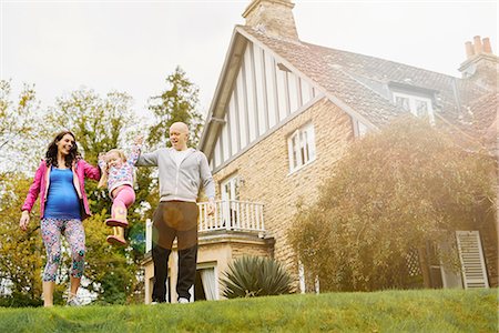 entre 3 y 4 años - Parents swinging daughter in garden Foto de stock - Sin royalties Premium, Código: 649-08578153