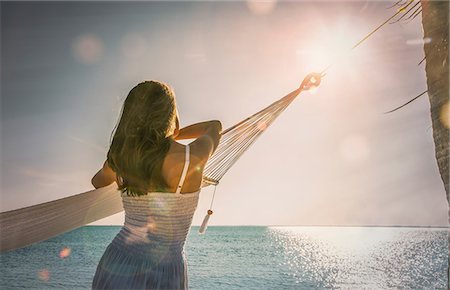 simsearch:614-08578277,k - Young woman leaning against hammock watching sunset on Miami Beach, Florida, USA Foto de stock - Sin royalties Premium, Código: 649-08578188