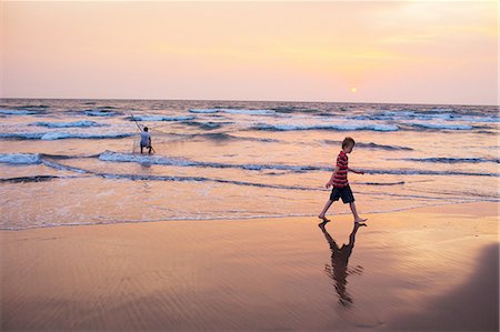 simsearch:6113-07160388,k - Boy walking in waves on beach Photographie de stock - Premium Libres de Droits, Code: 649-08632417