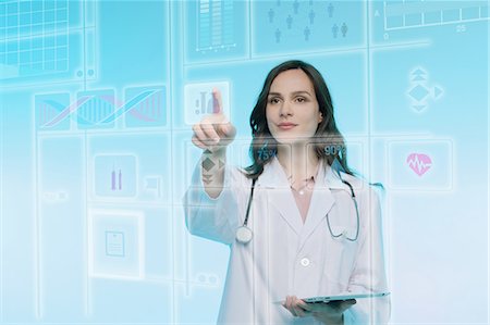 Female doctor holding digital tablet, touching graphical screen Stock Photo - Premium Royalty-Free, Code: 649-08660480