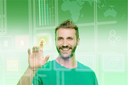 Young man touching recycling icon on graphical screen Stock Photo - Premium Royalty-Free, Code: 649-08660491