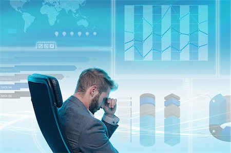 Man sitting in chair,  stressed expression, data on graphical screen behind him Stock Photo - Premium Royalty-Free, Code: 649-08660506