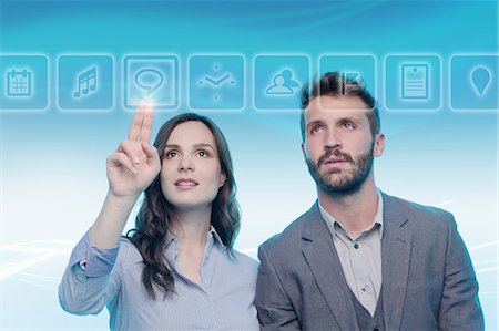 people hi tech data - Man and woman using graphical screen, woman touching icon Stock Photo - Premium Royalty-Free, Code: 649-08660503