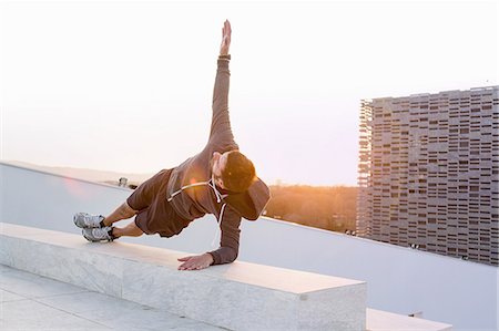 simsearch:649-08660568,k - Mid adult man exercising outdoors, in yoga position Photographie de stock - Premium Libres de Droits, Code: 649-08660569