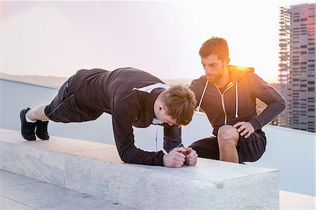 simsearch:649-08423361,k - Mid adult man helping young man exercise Stock Photo - Premium Royalty-Free, Code: 649-08660570