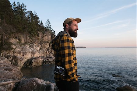 person with camera - Mid adult man standing beside lake, looking at view Stock Photo - Premium Royalty-Free, Code: 649-08660595