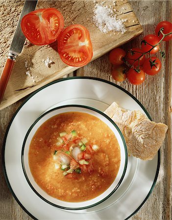 simsearch:649-08548238,k - Gazpacho soup with crusty ciabatta bread, freshly cut tomatoes on the vine and sea salt on rustic wooden chopping board, overhead view Foto de stock - Royalty Free Premium, Número: 649-08660606