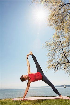 simsearch:614-08726424,k - Woman with arm and leg raised in yoga position Photographie de stock - Premium Libres de Droits, Code: 649-08660698