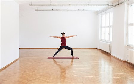 Woman in exercise studio arms open legs apart in yoga position Stock Photo - Premium Royalty-Free, Code: 649-08660712