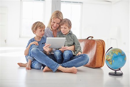 Mature woman and two son's sitting on floor looking at digital tablet together Foto de stock - Sin royalties Premium, Código: 649-08661046