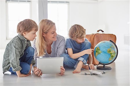 family suitcase vacations - Mature woman and two son's sitting on floor looking at globe Stock Photo - Premium Royalty-Free, Code: 649-08661043