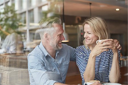 simsearch:649-08661396,k - View through window of mature couple in coffee shop face to face smiling Photographie de stock - Premium Libres de Droits, Code: 649-08661395