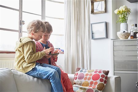 family looking at smart phone - Boys sitting on sofa looking at smartphone Stock Photo - Premium Royalty-Free, Code: 649-08661399