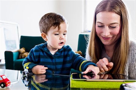 Mid adult woman and baby son using touchscreen on digital tablet at table Stock Photo - Premium Royalty-Free, Code: 649-08661504