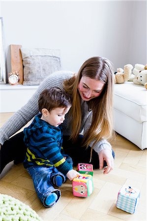 simsearch:649-08661490,k - Mid adult woman playing with baby son on playroom floor Photographie de stock - Premium Libres de Droits, Code: 649-08661501