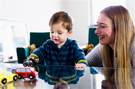 simsearch:649-08661490,k - Mid adult woman and baby son playing with toy cars on table Photographie de stock - Premium Libres de Droits, Code: 649-08661503