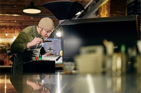 Male coffee shop owner smelling coffee from coffee roaster Stock Photo - Premium Royalty-Free, Code: 649-08661596