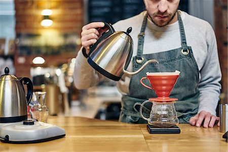 simsearch:649-08661633,k - Barista pouring boiling water into coffee filter at coffee shop Foto de stock - Sin royalties Premium, Código: 649-08661610