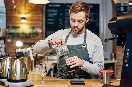 simsearch:649-08661633,k - Male barista pouring coffee at coffee shop kitchen counter Foto de stock - Sin royalties Premium, Código: 649-08661612