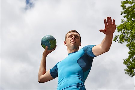 simsearch:649-06844269,k - Low angle view of young male handball player preparing to throw ball Fotografie stock - Premium Royalty-Free, Codice: 649-08661719