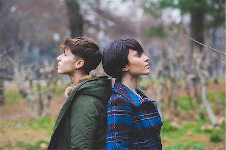 Two young women standing back to back in rural setting Foto de stock - Sin royalties Premium, Código: 649-08661771