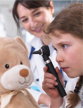 simsearch:649-08662036,k - Girl using otoscope to examine teddy bear Stock Photo - Premium Royalty-Free, Code: 649-08662035