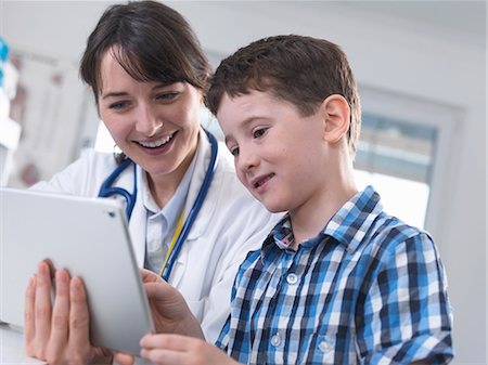 sick kid smiling - Doctor and boy using digital tablet Stock Photo - Premium Royalty-Free, Code: 649-08662036