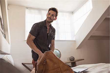 Man in bedroom packing bag Foto de stock - Sin royalties Premium, Código: 649-08662087