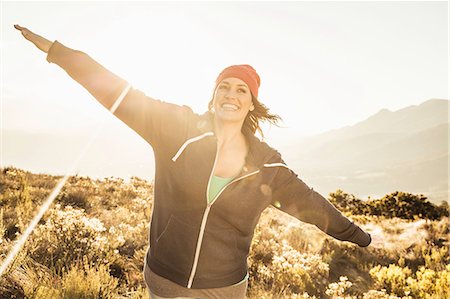 simsearch:649-08824455,k - Woman in field, arms open, looking at camera smiling Stock Photo - Premium Royalty-Free, Code: 649-08662124