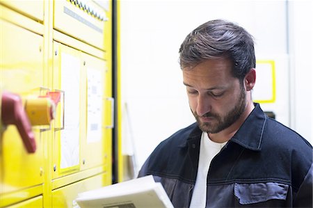 Man holding instruction manual by control panel Photographie de stock - Premium Libres de Droits, Code: 649-08662160