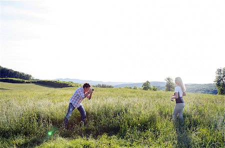 simsearch:649-08924077,k - Man photographing woman in field Photographie de stock - Premium Libres de Droits, Code: 649-08662175