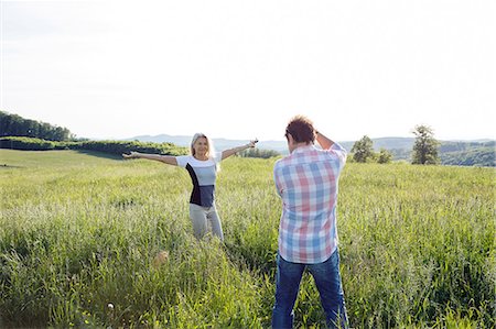 simsearch:649-08924077,k - Man photographing woman in field Photographie de stock - Premium Libres de Droits, Code: 649-08662176