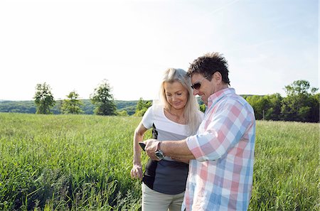 simsearch:649-08924077,k - Mature couple looking at smartphone in field Photographie de stock - Premium Libres de Droits, Code: 649-08662177