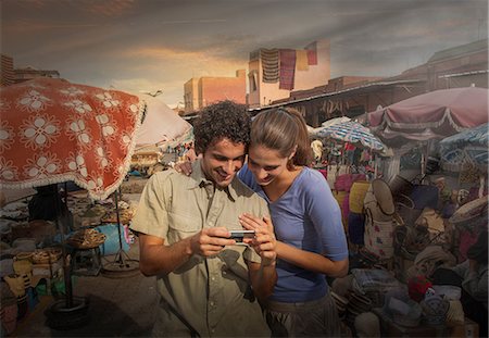 Young couple at market looking at digital camera, Jemaa el-Fnaa Square, Marrakesh, Morocco Stock Photo - Premium Royalty-Free, Code: 649-08662280