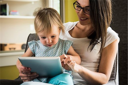 Mother teaching daughter to use digital tablet at home Stock Photo - Premium Royalty-Free, Code: 649-08702094