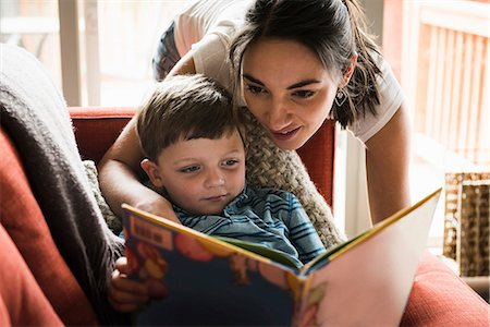 Mother teaching son to read book on sofa Stock Photo - Premium Royalty-Free, Code: 649-08702101