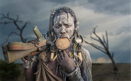 painted faces - Woman of the Mursi tribe with Kalashnikov gun, Omo Valley, Ethiopia Stock Photo - Premium Royalty-Free, Code: 649-08702295