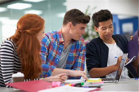 Young female and two male college students teamworking at desk Stock Photo - Premium Royalty-Free, Code: 649-08702326