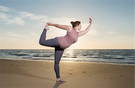 en pied - Mature woman practising yoga on a beach at sunset, tree pose Photographie de stock - Premium Libres de Droits, Code: 649-08702377