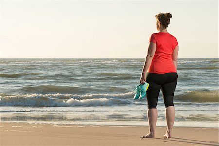 Mature woman standing on beach at sunset, after running Stock Photo - Premium Royalty-Free, Code: 649-08702373