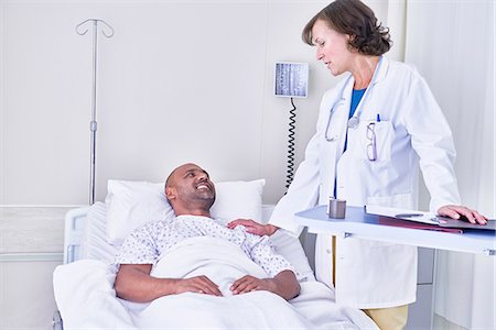 doctor patient asian not eye contact - Doctor consulting with patient lying in hospital bed Stock Photo - Premium Royalty-Free, Code: 649-08702560