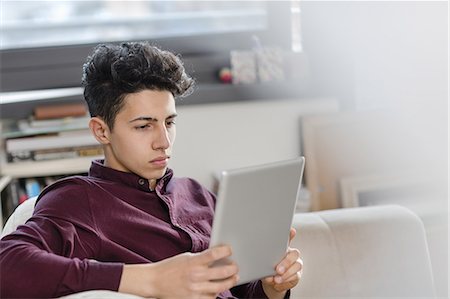 simsearch:649-08702598,k - Young man on sofa using digital tablet Stock Photo - Premium Royalty-Free, Code: 649-08702595